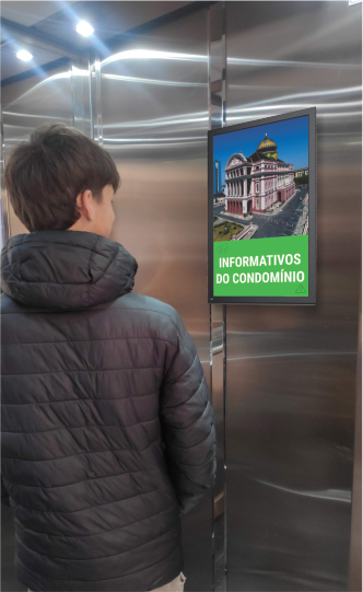 Moradores assistindo a tela no elevador